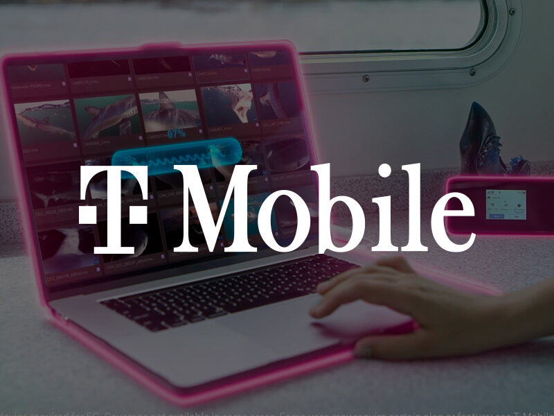 T-Mobile logo over and image of a pink glowing laptop and cell phone on a desk.